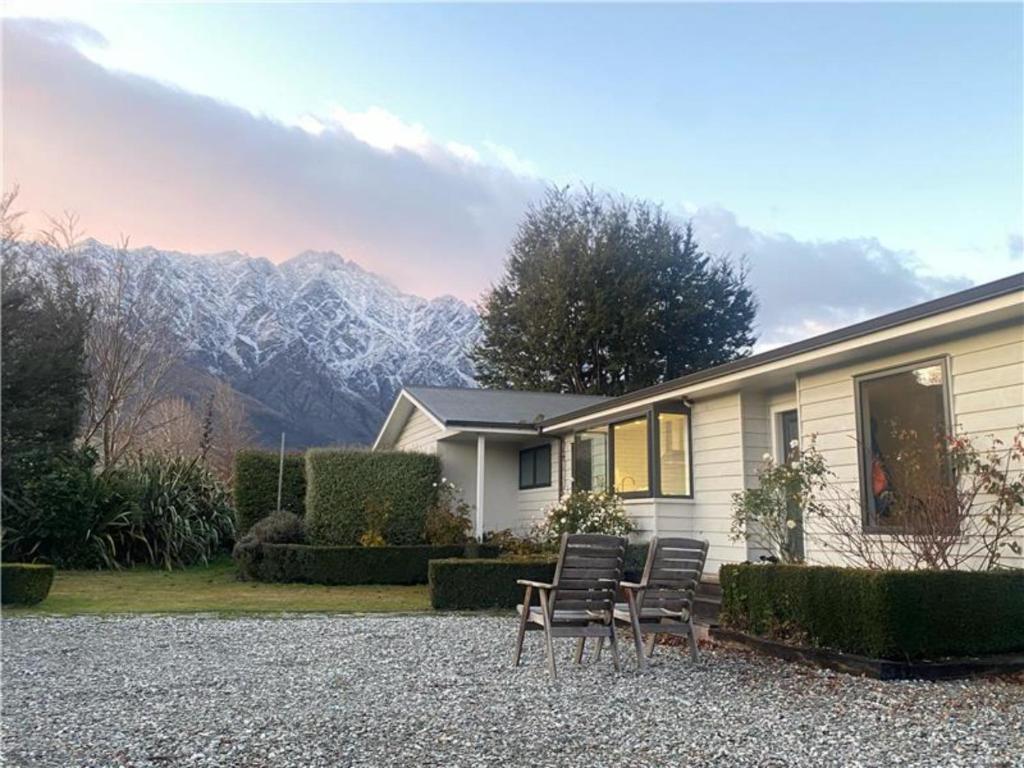 a house with a table and chairs in front of it at Frankton Favourite - Queenstown Holiday Home in Queenstown