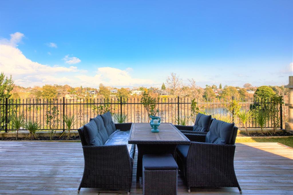 a patio with a table and chairs and a fence at Wonderful River View-Brand New Home - 4 Bedrooms in Hamilton