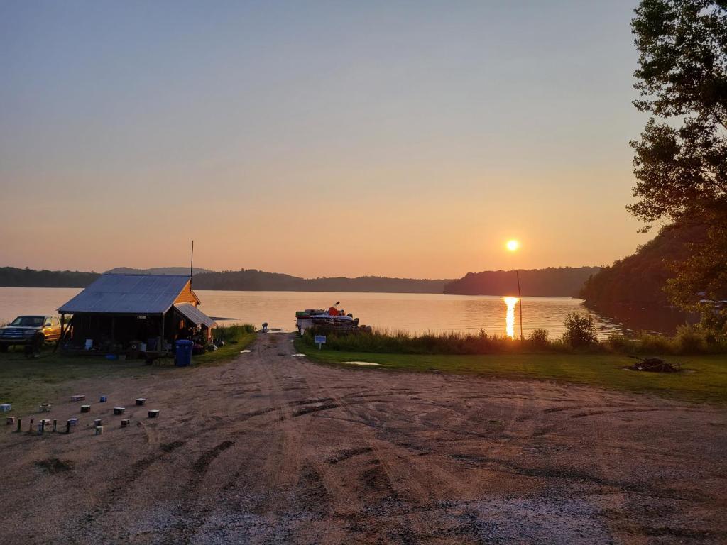 einen Sonnenuntergang über einem See mit einem Haus und Vögeln in der Unterkunft Chalet with great lake view in Gracefield