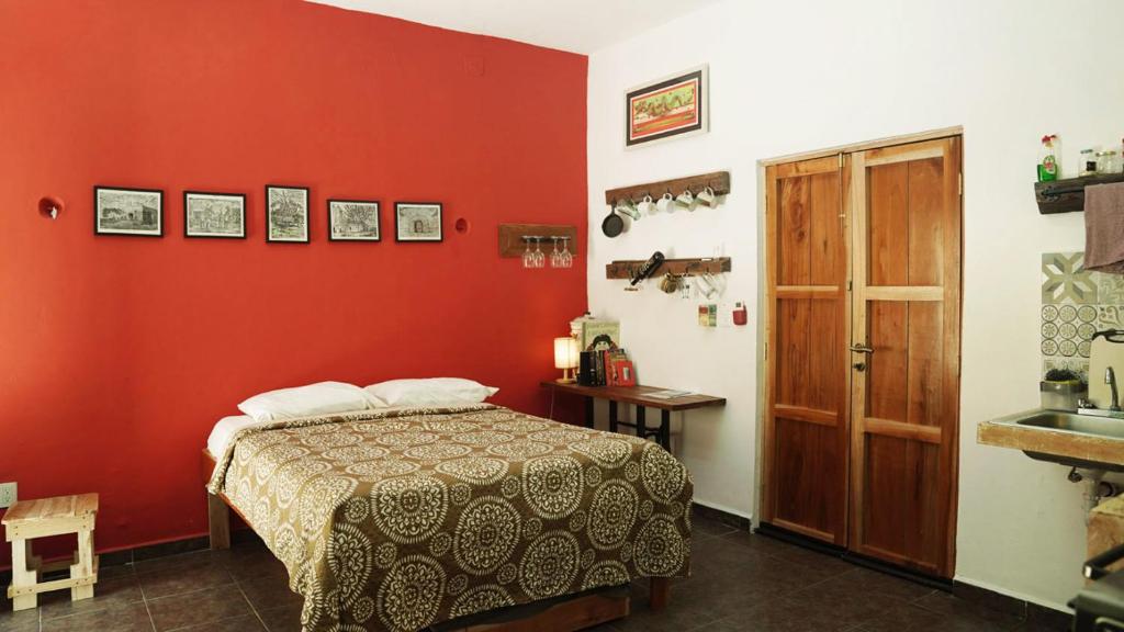 ein rotes Zimmer mit einem Bett und einem Waschbecken in der Unterkunft Habitacion Roja / Casa del Café in Campeche