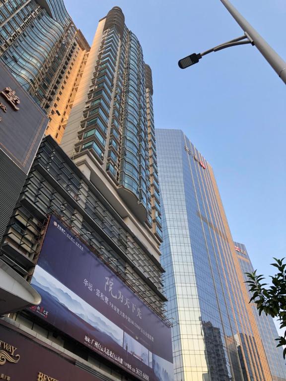 a tall building with a billboard in front of it at Xingyu Apartment - Tianhe Road in Guangzhou