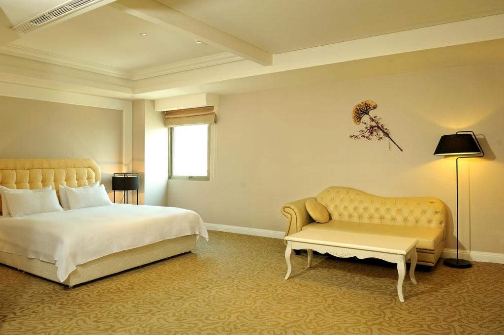 台南的住宿－亞帝大飯店 ，一间卧室配有一张床和一张沙发