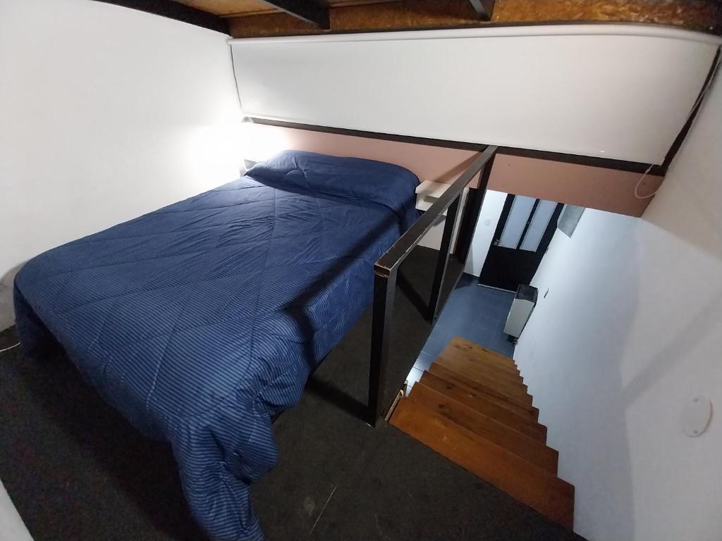 Un pequeño dormitorio con una cama azul en una habitación en Espacio km3 en Comodoro Rivadavia