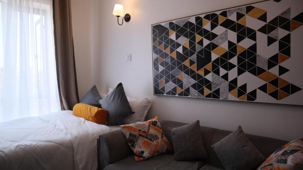 a living room with a bed and a couch at El Hogar near UN Headquarters, Gigiri in Kiambu