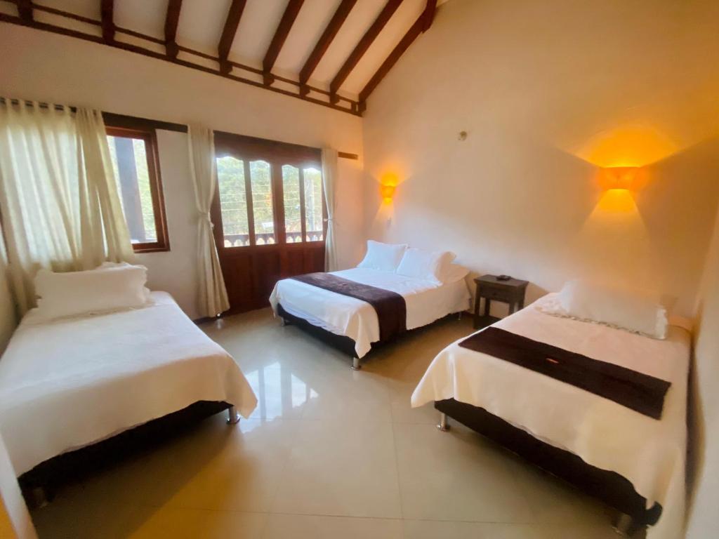 a bedroom with two beds in a room at Hotel Oasis de la villa in Villa de Leyva