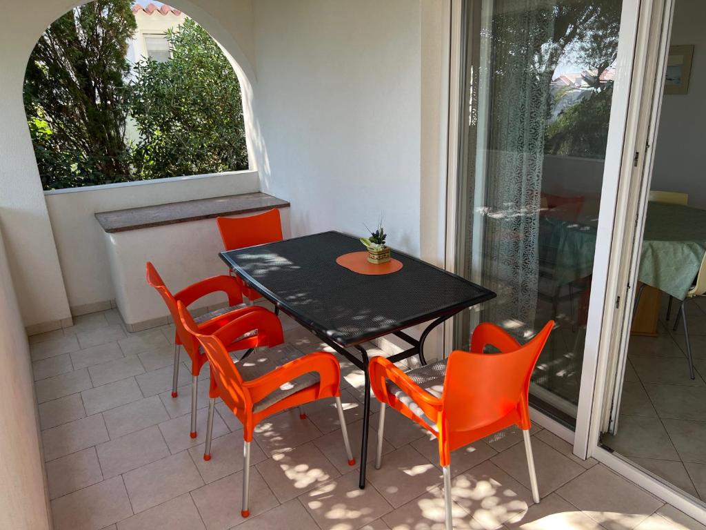 a table and chairs in a room with a window at Apartments MiaMaja in Novalja