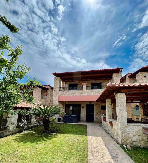 a large stone building with a palm tree in front of it at #ALS- Stone Maisonette in Paliouri in Paliouri