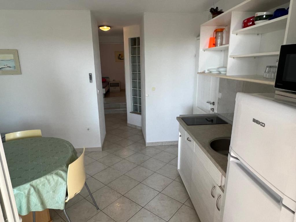 a small kitchen with a table and a sink at Apartments MiaMaja in Novalja