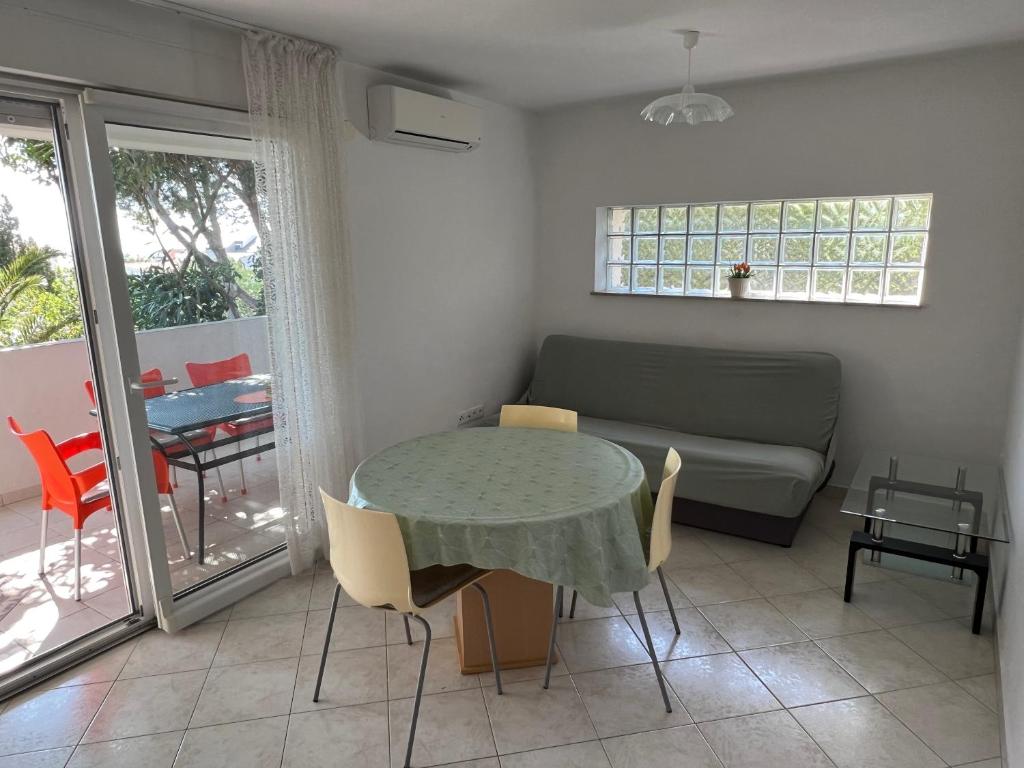 a living room with a table and a couch at Apartments MiaMaja in Novalja