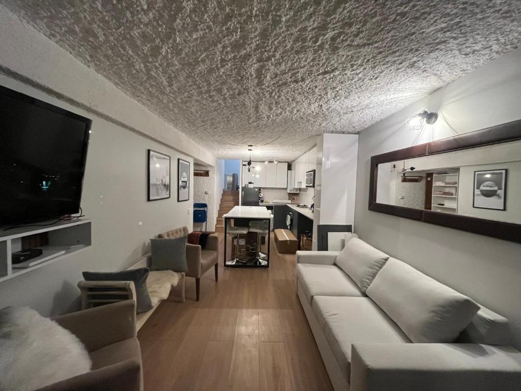 - un salon avec un canapé blanc et une télévision dans l'établissement Ski in-out Apartment in El Colorado, à El Colorado