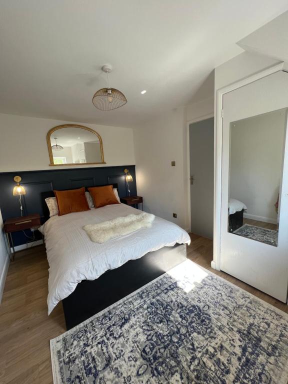 a bedroom with a bed with a mirror and a rug at The Raven's Loft by Harry Potter in Garston