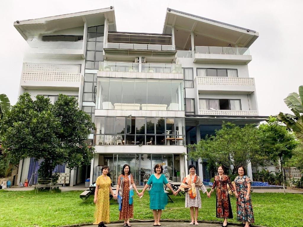 un grupo de mujeres frente a un edificio en Nature Key Retreat Gia Trịnh - Ba Vì, en Hanói