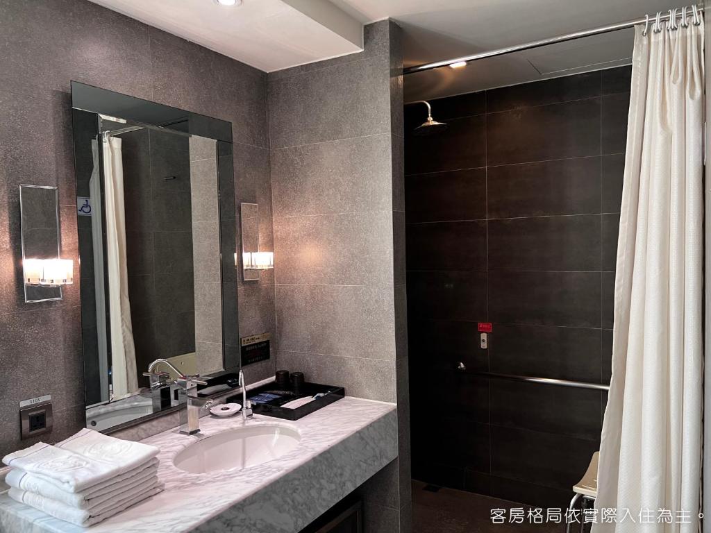 a bathroom with a sink and a shower at Talmud Hotel Kaohsiung LoveRiver in Kaohsiung