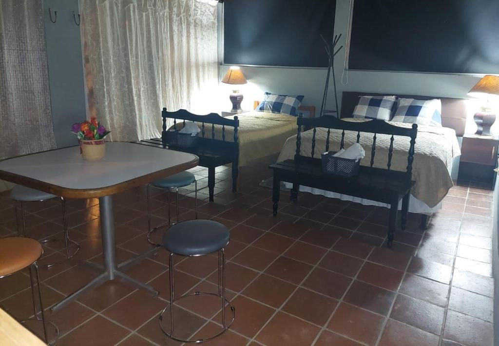 1 dormitorio con 1 cama, mesa y sillas en Nirvana 2, Habitación doble con todos sus servicios, en Guatemala