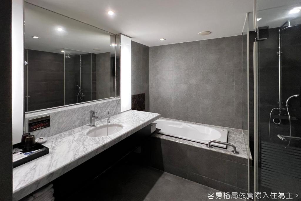 a bathroom with a tub and a sink and a shower at Talmud Hotel Kaohsiung LoveRiver in Kaohsiung