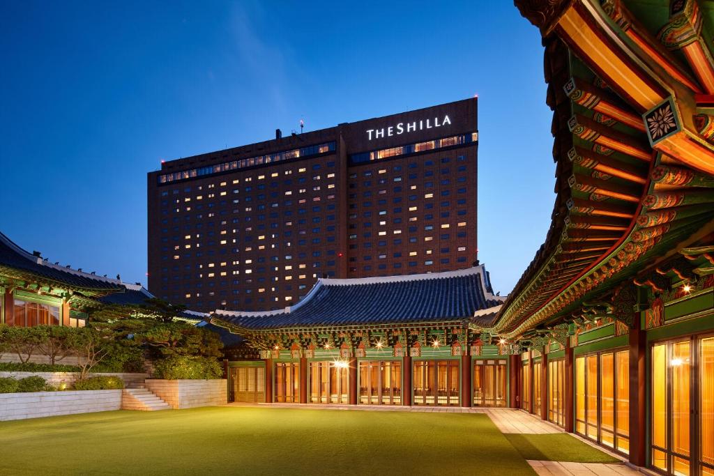 a building with a green lawn in front of a building at The Shilla Seoul in Seoul