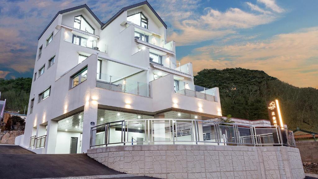 a large white building with a lot of windows at Geoje Le Soleil Pool Villa Pension in Geoje
