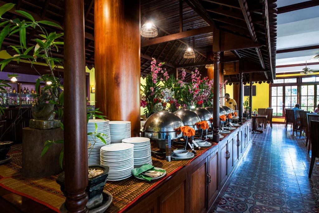 a restaurant with a buffet line with plates and plants at Royal Crown Hotel & Spa in Siem Reap