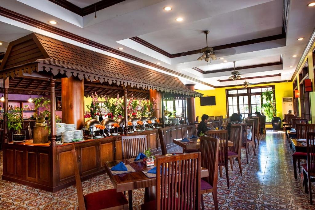 a restaurant with tables and chairs and a bar at Royal Crown Hotel & Spa in Siem Reap