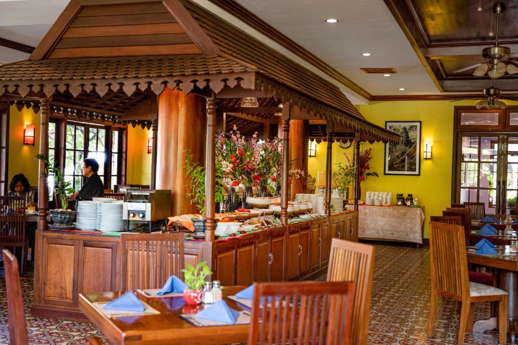 a restaurant with tables and a chef preparing food at Royal Crown Hotel & Spa in Siem Reap