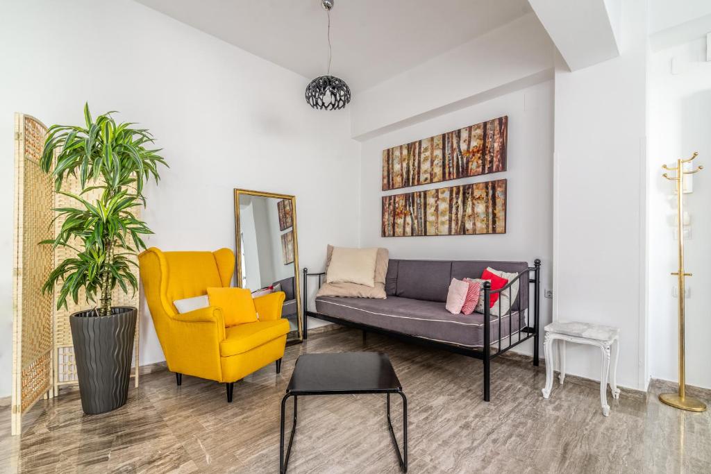 a living room with a couch and a yellow chair at Evangeline City Center Apartment AC/WiFi in Heraklio