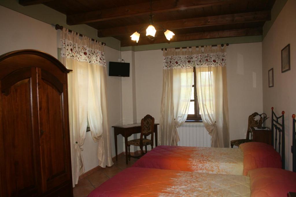sypialnia z łóżkiem, stołem i oknem w obiekcie Agriturismo Cascina Nuova w mieście Barge