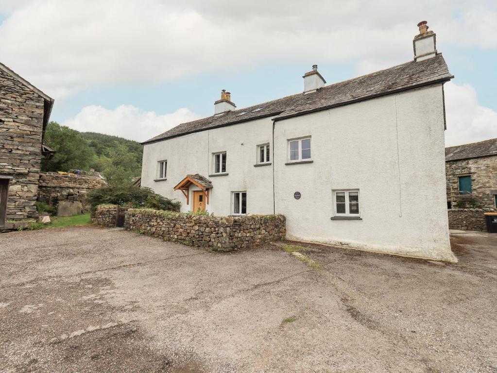 a large white house with a stone wall at Satterthwaite Farmhouse - Sleep 8 in Grizedale