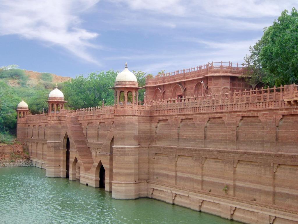 un gran puente de ladrillo sobre un cuerpo de agua en WelcomHeritage Bal Samand Lake Palace en Jodhpur