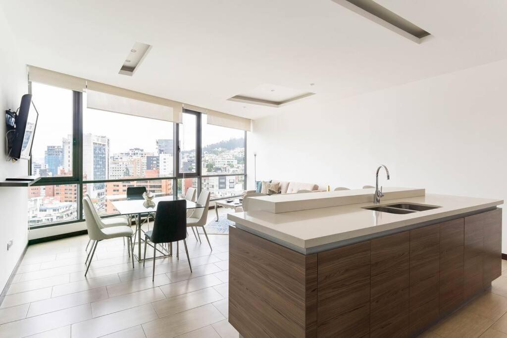 a kitchen with a sink and a table with chairs at Luxury penthouse apartment in Quito