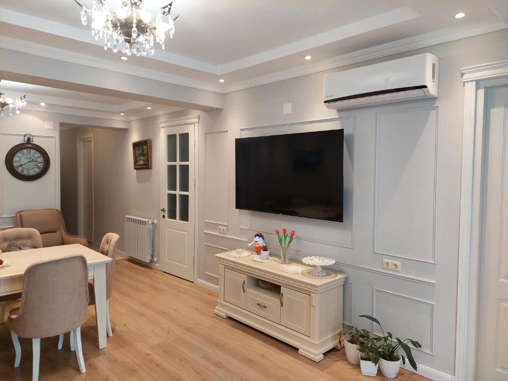 un soggiorno con un tavolo e una televisione su una parete di luxe apartment a Batumi