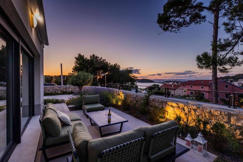 un patio con divani e un tavolo sul balcone. di Apartments Olea a Mali Lošinj (Lussinpiccolo)