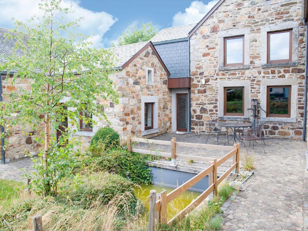 a stone cottage with a wooden bridge in front of it at Beautiful g te in Jalhay 5 minutes from the Hautes Fagnes in Tiège