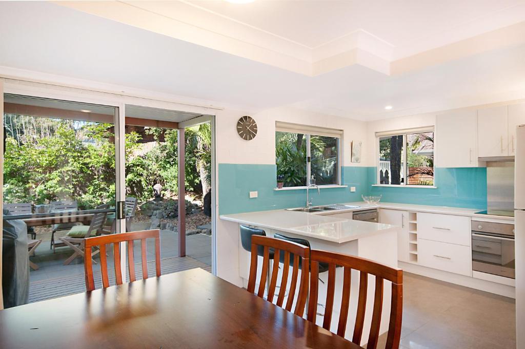 a kitchen with a table and chairs and a dining room at Shivas@Byron... minutes walk to Main Beach! in Byron Bay