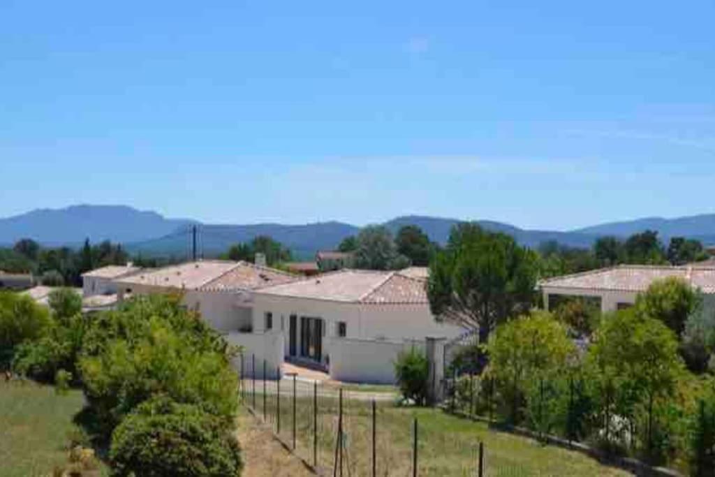une maison blanche avec une clôture dans une cour dans l'établissement L’échappée belle Au cœur de la Provence verte, à Saint-Maximin-la-Sainte-Baume