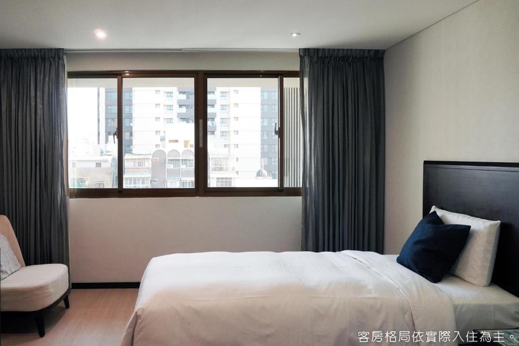 a bedroom with a large bed and a window at Talmud Hotel Kaohsiung LoveRiver in Kaohsiung