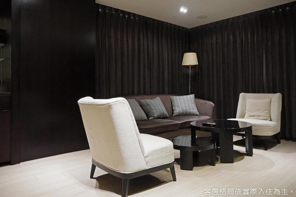 a living room with a couch and two chairs and a table at Talmud Hotel Kaohsiung LoveRiver in Kaohsiung
