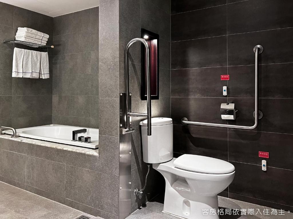 a bathroom with a toilet and a bath tub at Talmud Hotel Kaohsiung LoveRiver in Kaohsiung