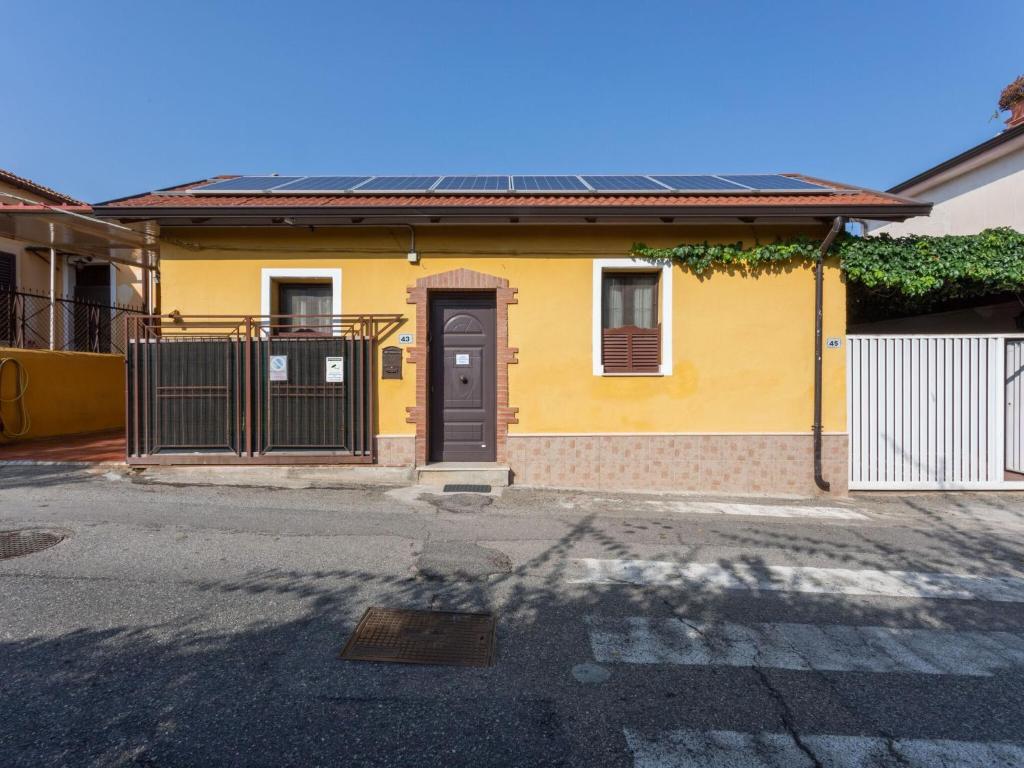 een geel huis met een zwarte deur in een straat bij Villa in Villa San Giovanni near Aspromonte National Park in Villa San Giovanni