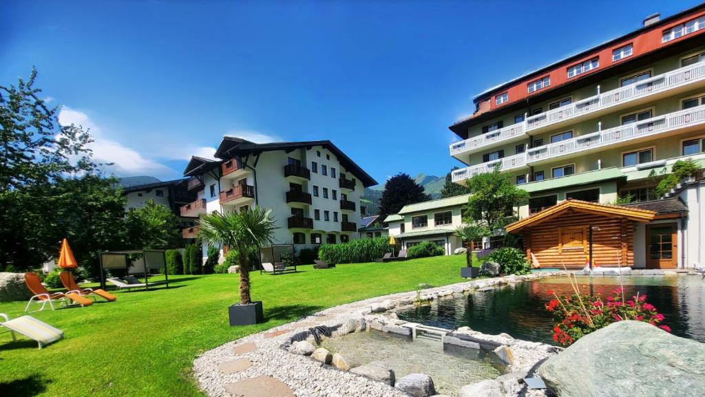 a hotel yard with a pond and buildings at Hotel Rauscher und Paracelsus in Bad Hofgastein