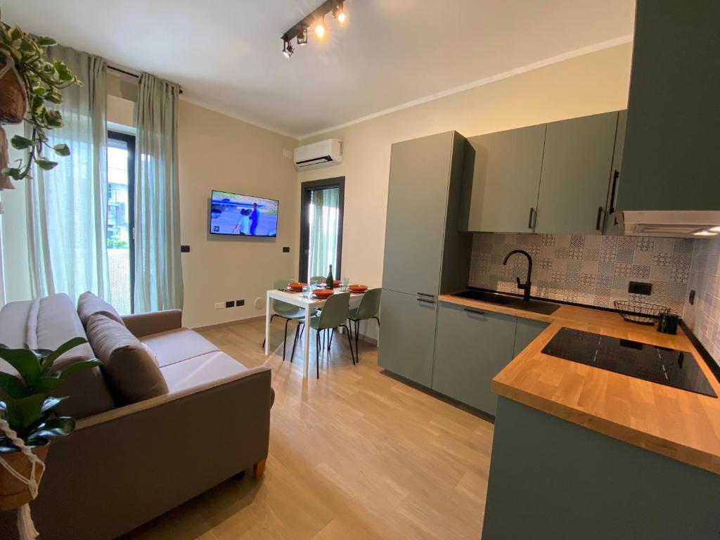 uma cozinha e sala de estar com um sofá e uma mesa em Appartamento a 200 mt dal mare em Rimini
