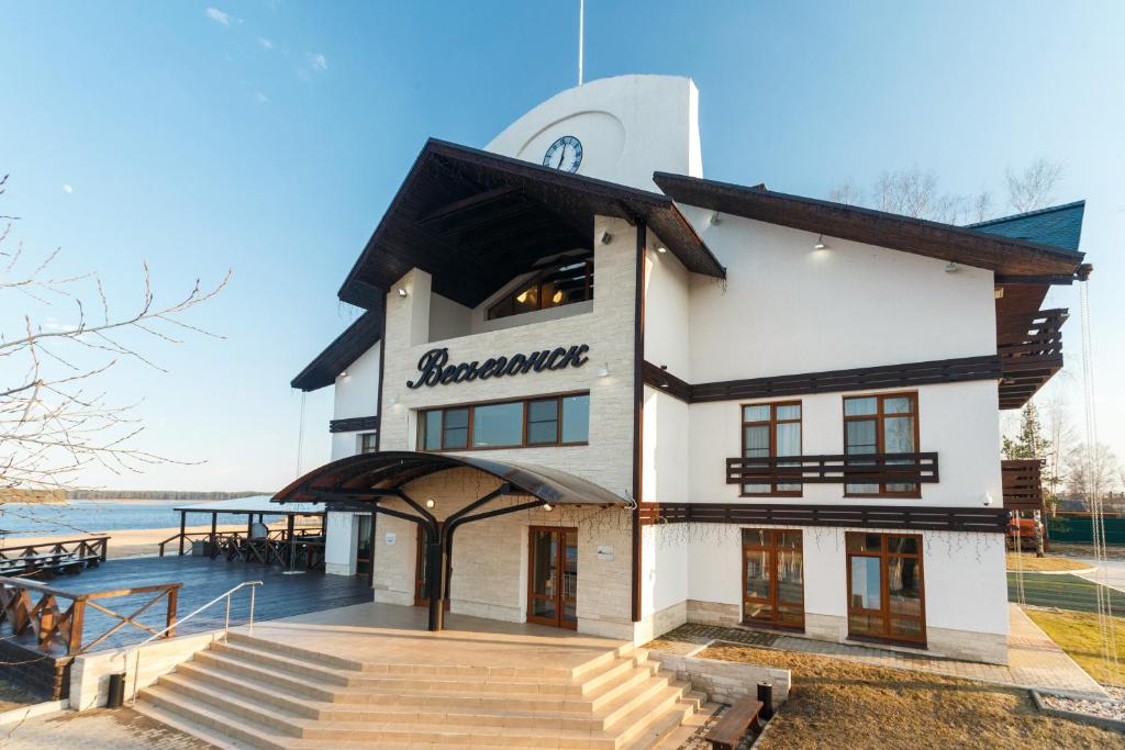 a building with a staircase in front of the water at Port Vesiegonsk Hotel in Ves'yegonsk