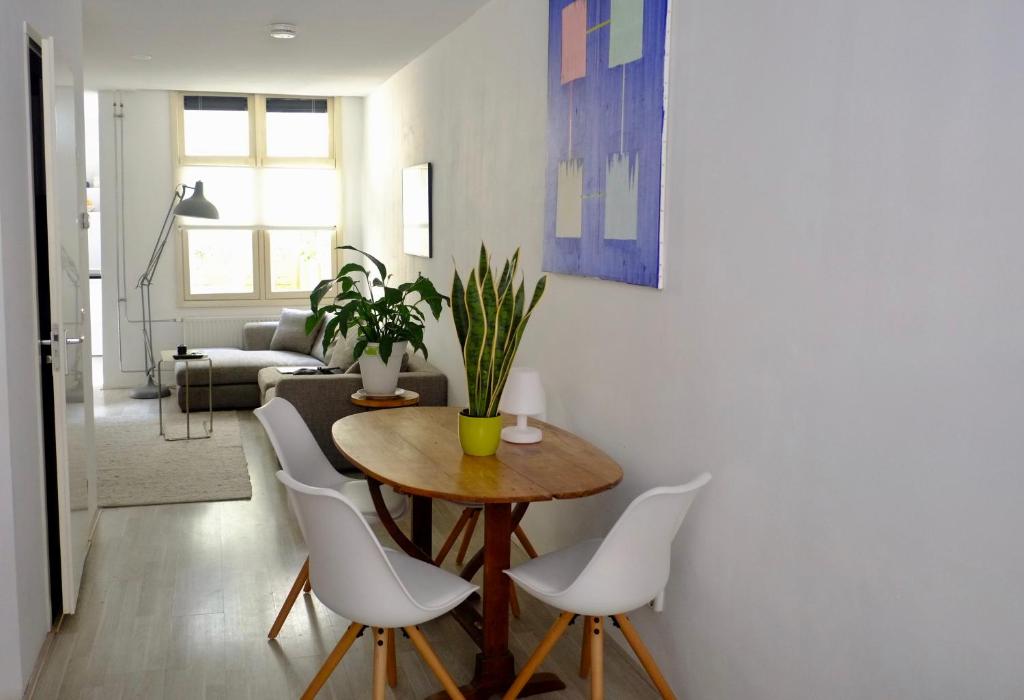 阿姆斯特丹的住宿－Ground Floor Apartment Westerpark，客厅配有桌子和白色椅子