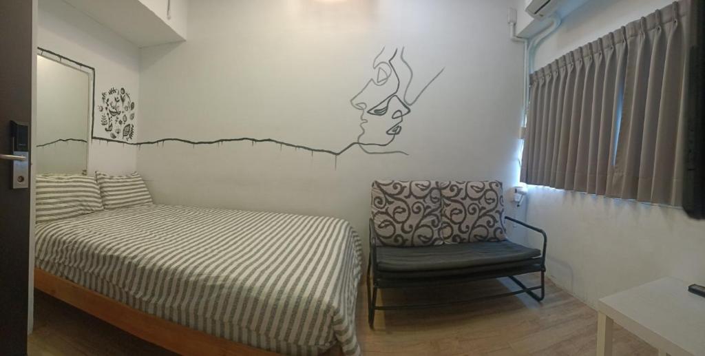 1 dormitorio pequeño con 1 cama y 1 silla en 心旅地圖青年旅館, en Changhua City