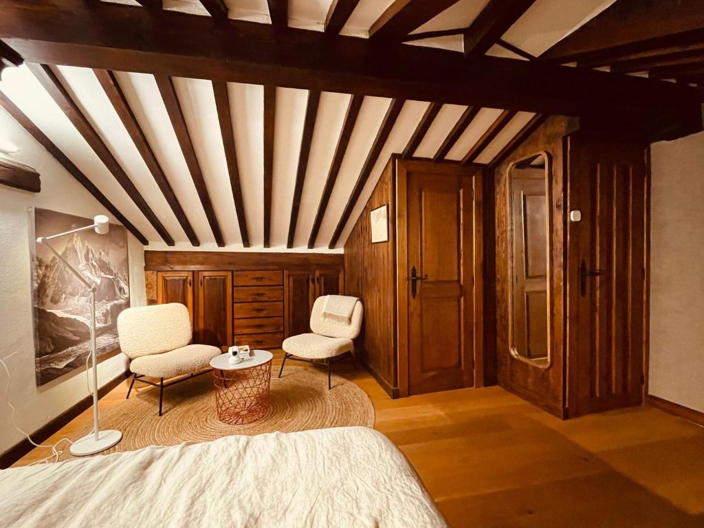 a bedroom with a bed and two chairs and a ceiling at LITTLE TOWER in Potes