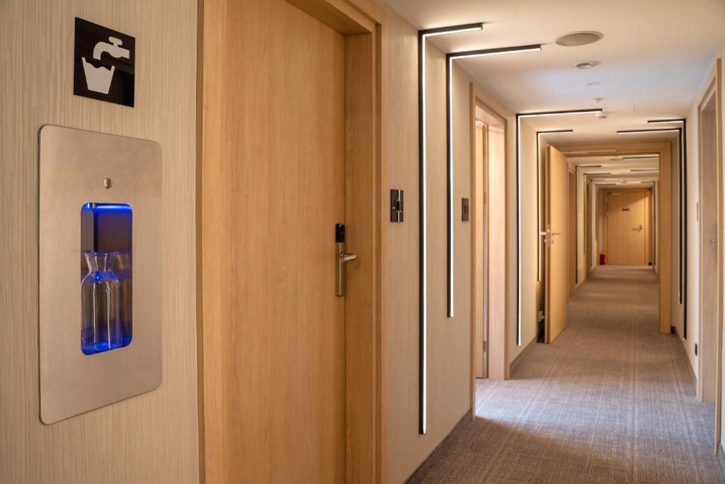 a corridor of corridors in a hospital with a blue door at Hotel Alexander in Krakow