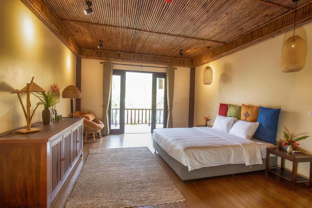 um quarto com uma cama grande e um tecto em madeira em HỒ ĐÁ CỔ THIÊN LONG Hoa Le em Hòa Bình