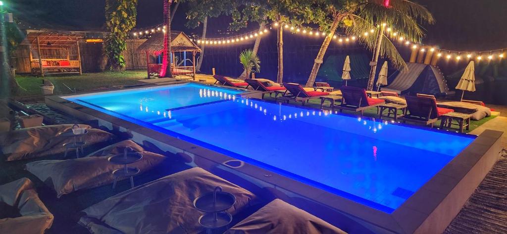 una piscina por la noche con sillas y luces en kids Heaven Villa, en Koh Samui 