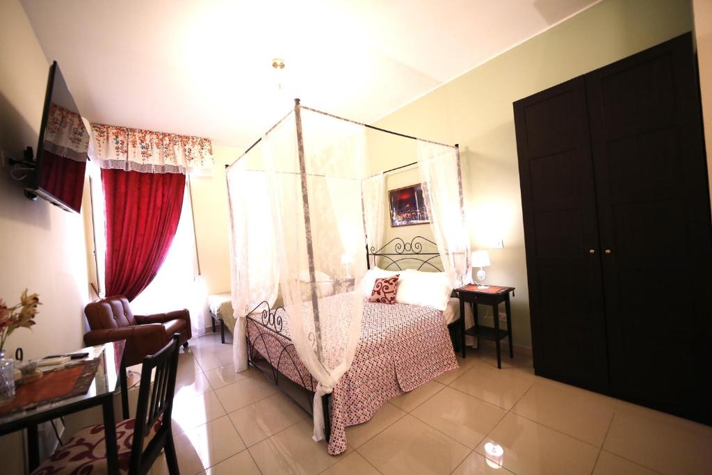 ein Schlafzimmer mit einem Himmelbett in einem Zimmer in der Unterkunft Al Quadrato D'Oro rooms in Catania