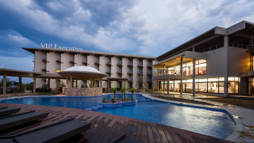 a hotel with a swimming pool in front of a building at Hotel Vip Executive Tete in Vila-de-Santiago-Maior