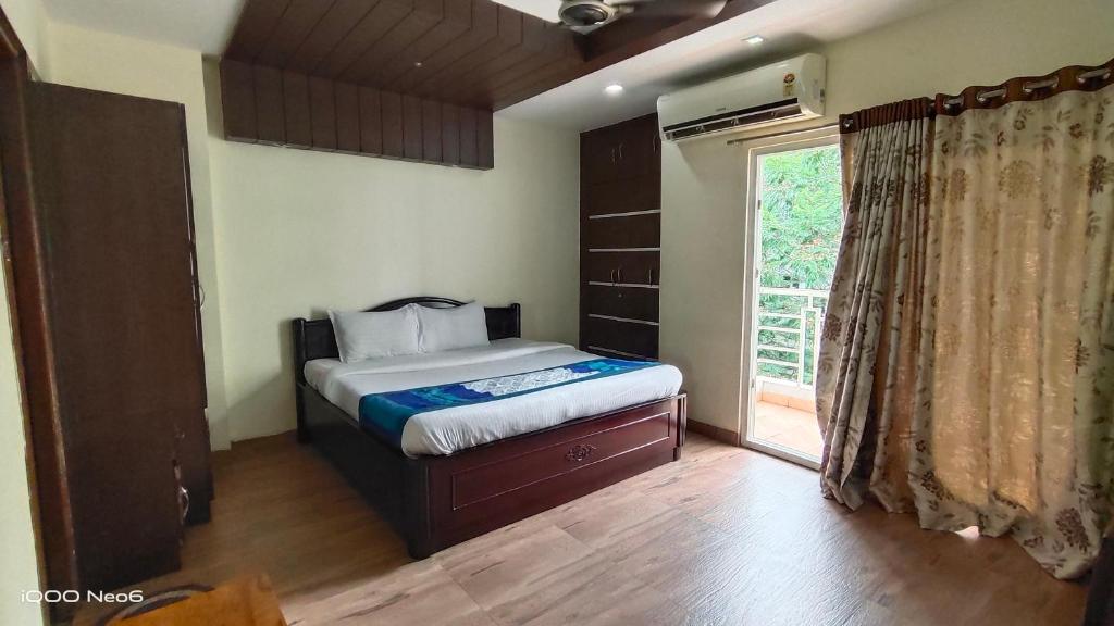 a bedroom with a bed and a large window at Hitech Shilparamam Guest House in Hyderabad